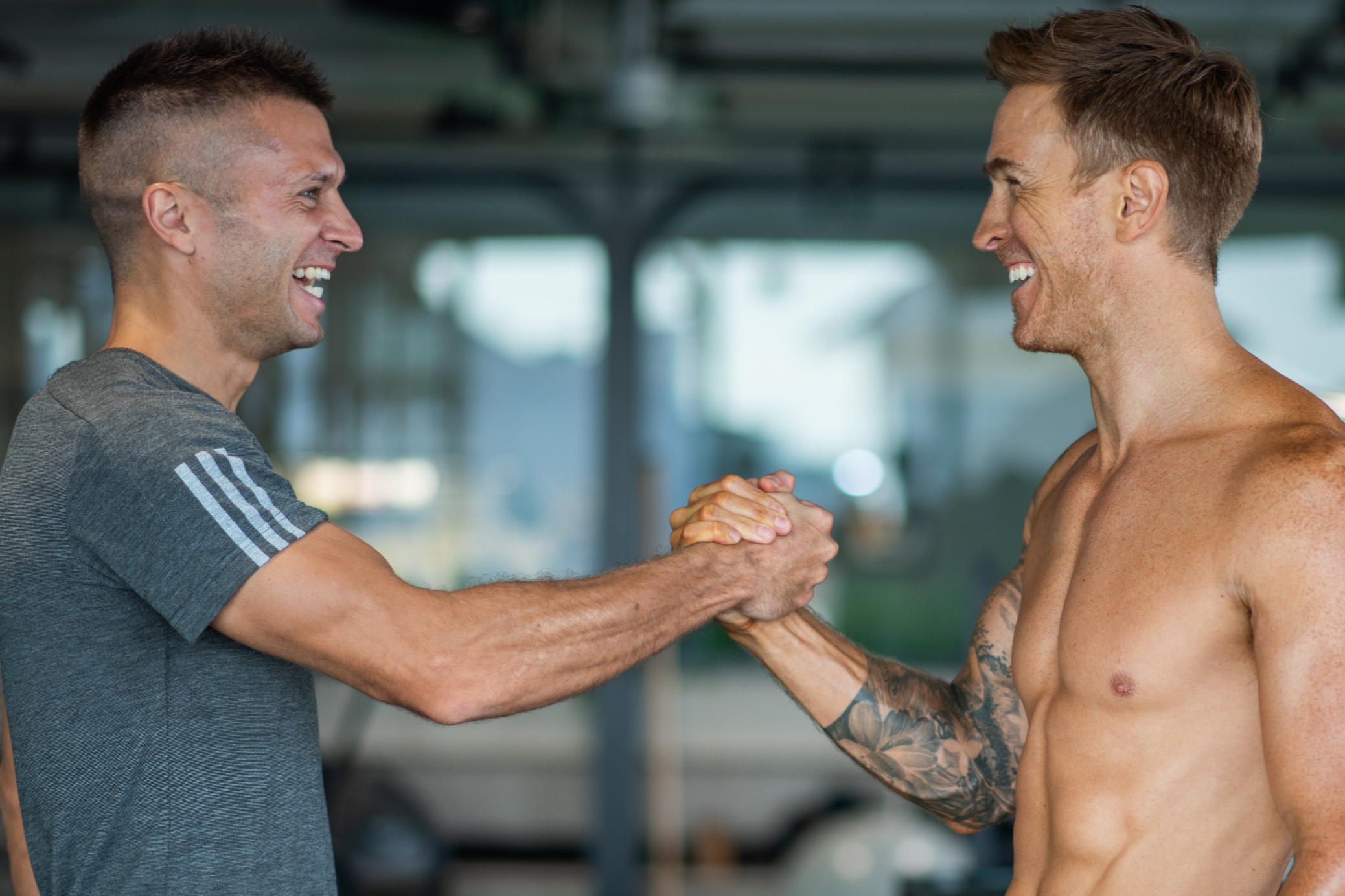 Tom Hine celebrating success with a transformed client in professional gym setting